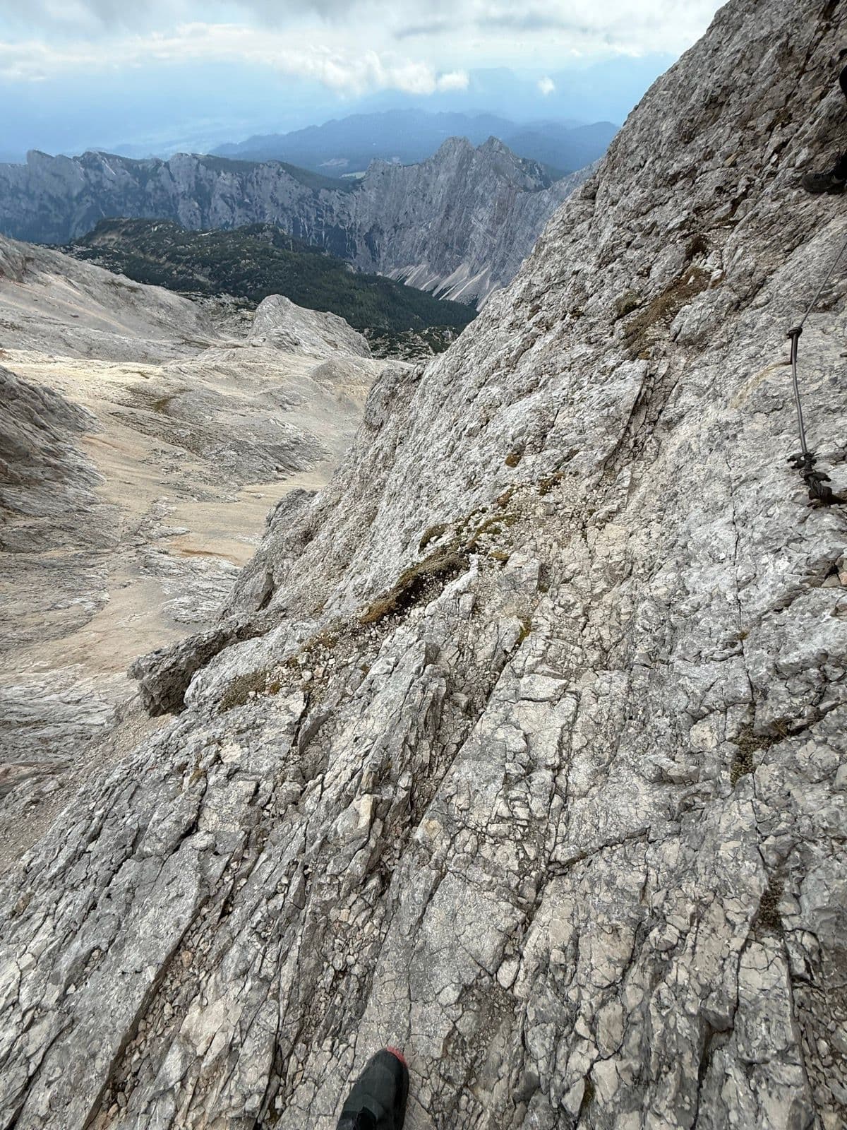 Steep rocky mountain trail with a metal safety cable on Mount Triglav, Slovenia.