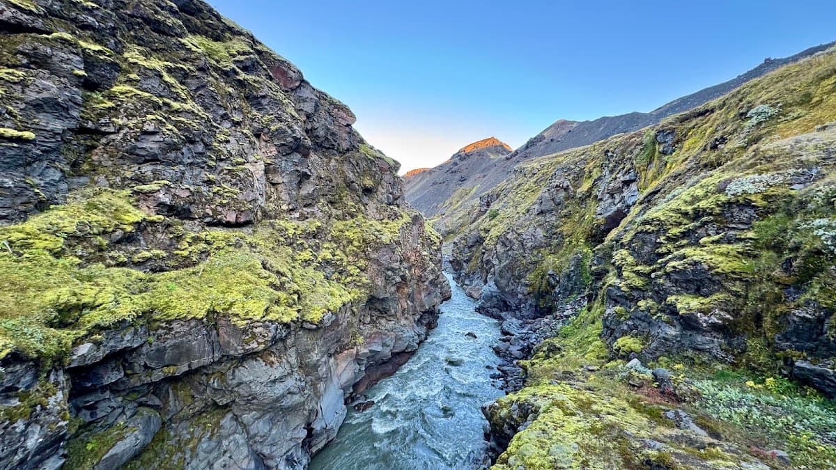 River flowing through steep rocky canyon with green mossy cliffs