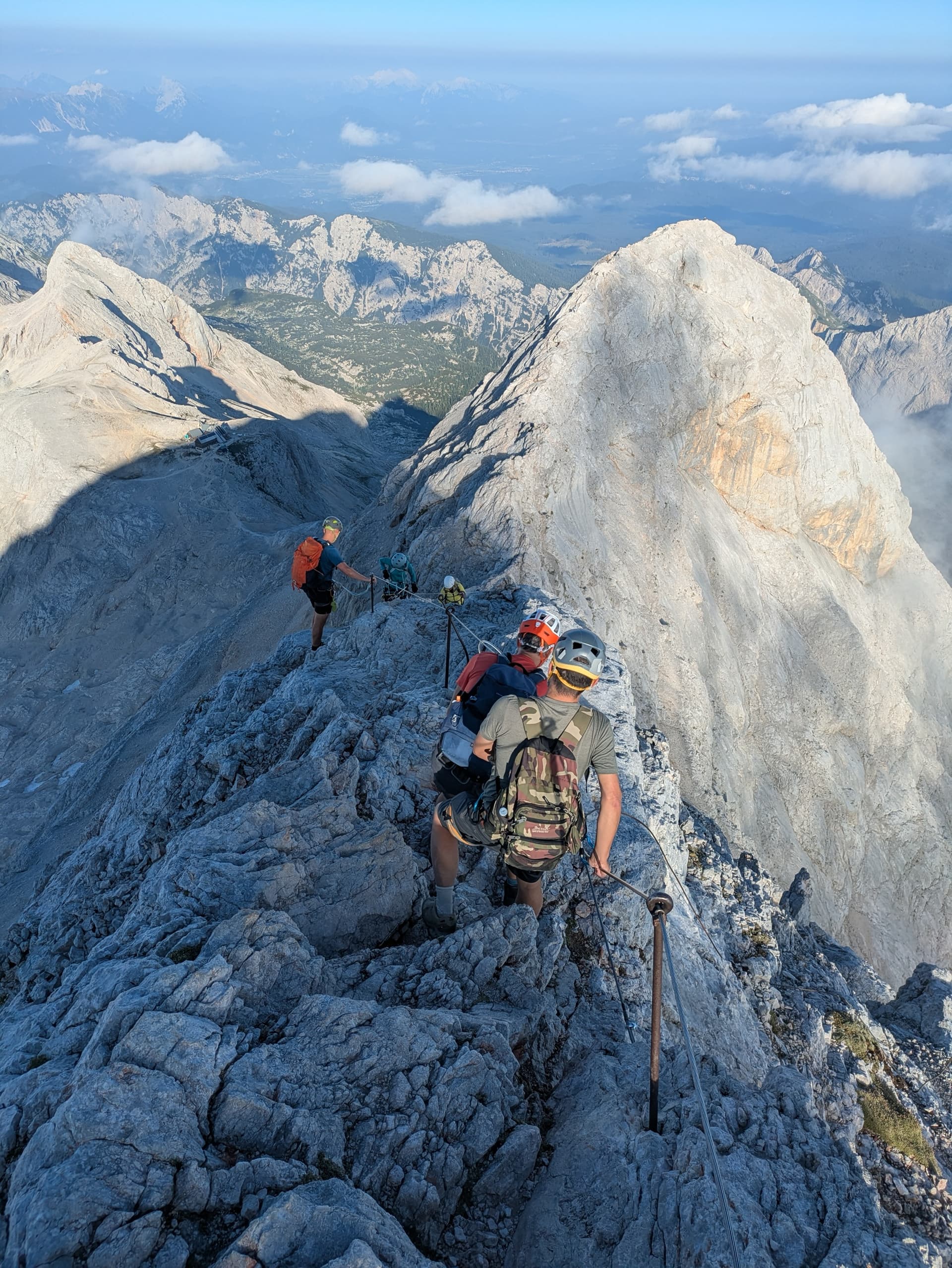Climbers on Triglav ridge with safety cable in Julian Alps