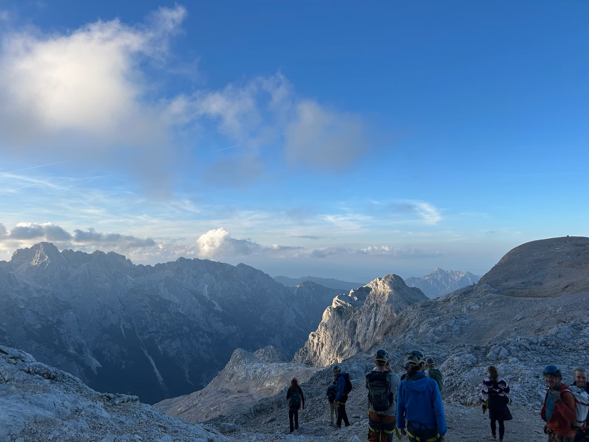 Group of hikers standing on high mountain ridge at sunrise