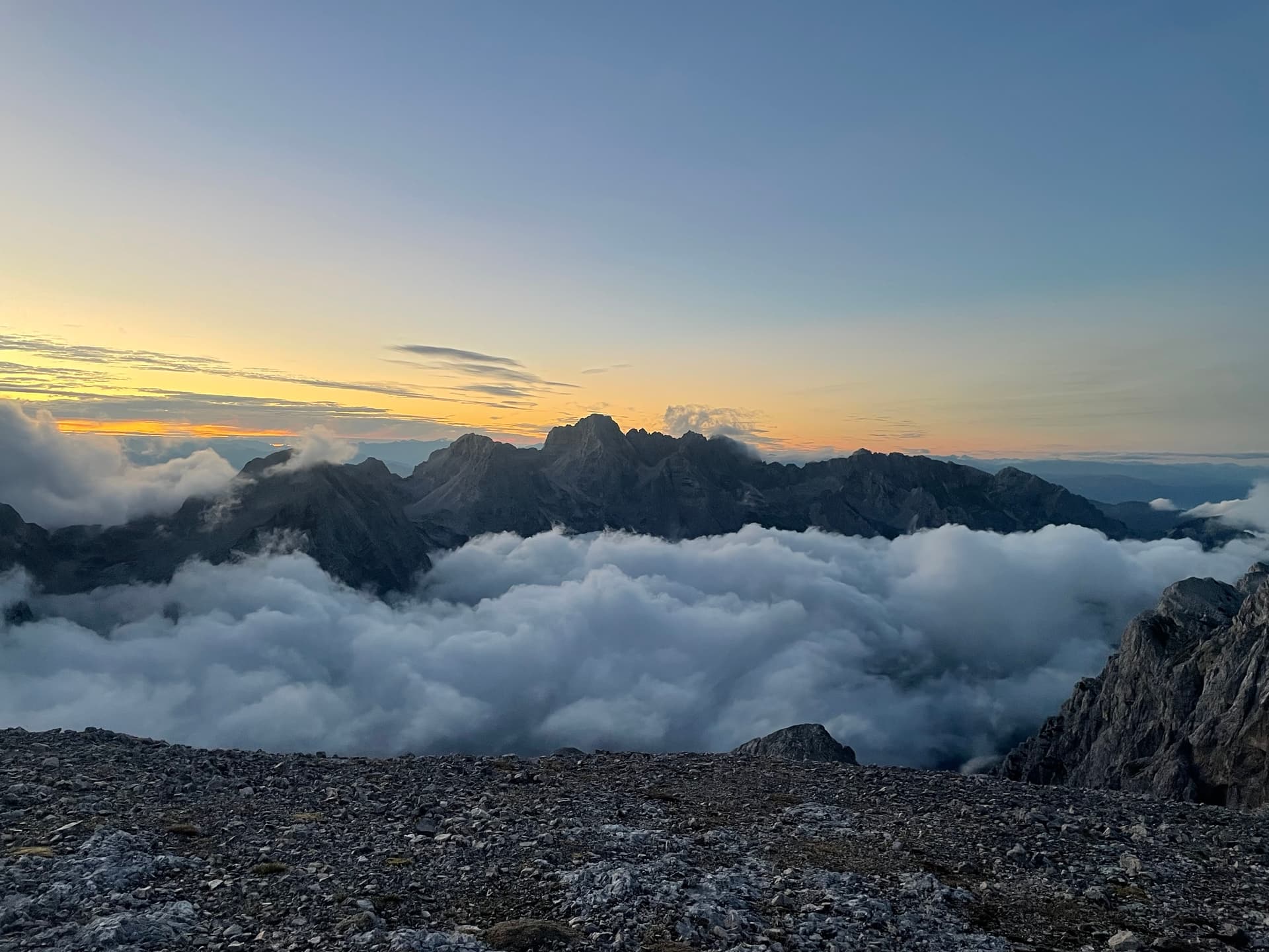 Mountain peaks rising above sea of clouds at sunrise