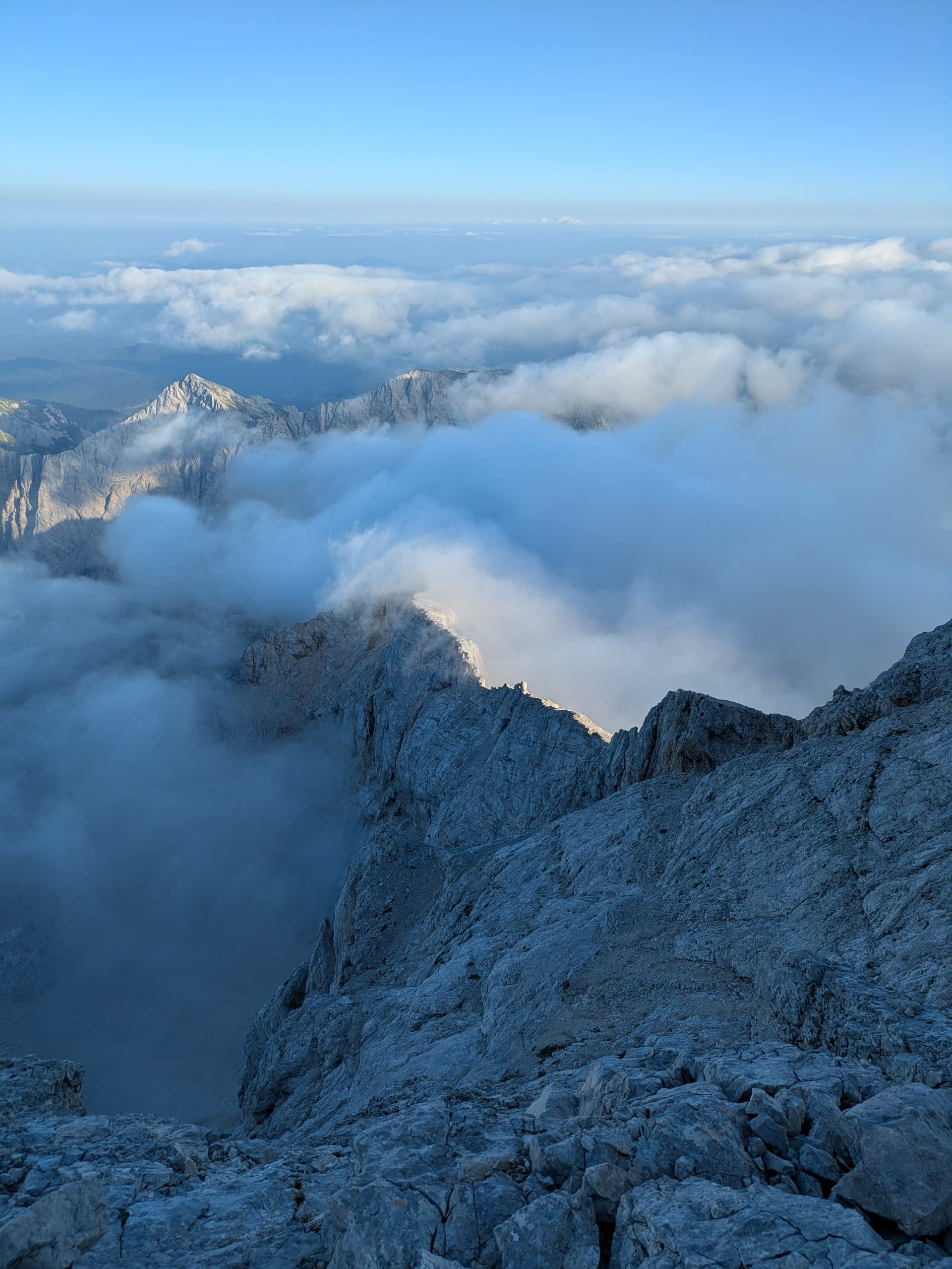 Alpine mountain peaks rising above a sea of clouds filling the valleys