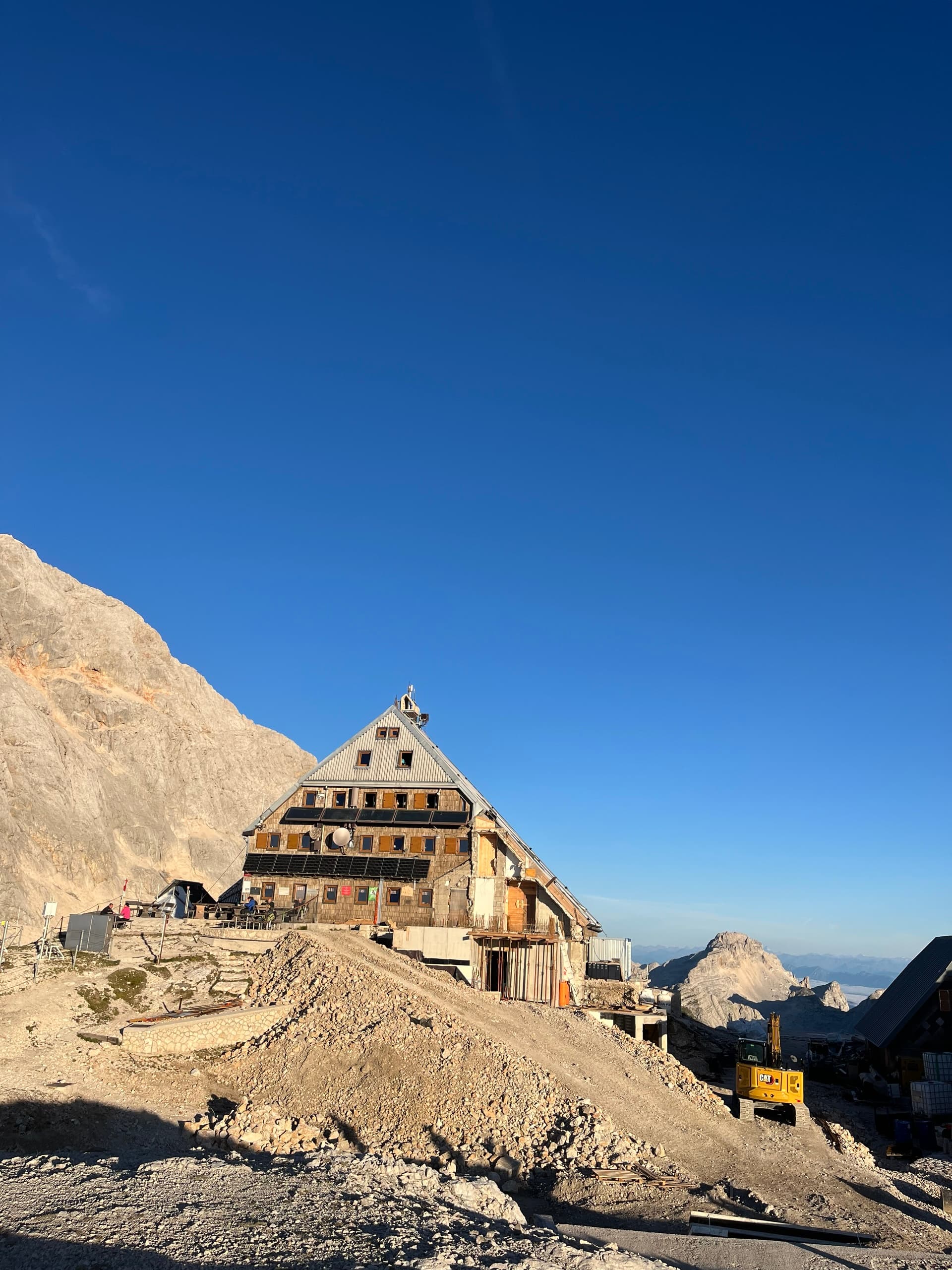 Mountain hut on a high ridge under a clear blue sky