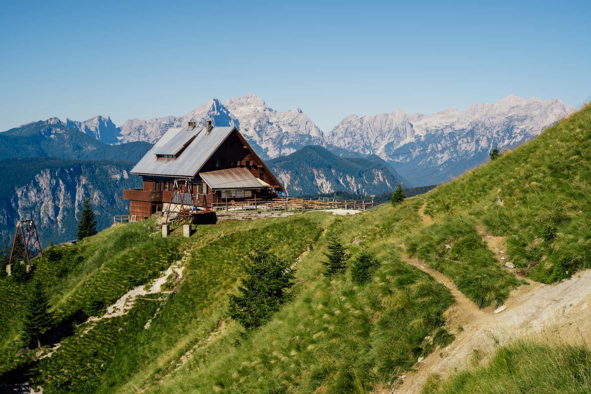 Koča na Golici mountain hut in the Julian Alps with hiking trail and jagged peaks